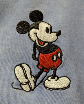 Vista de cerca de un bordado con hilo de Mickey Mouse de Disney en un dise&ntilde;o cl&aacute;sico, sobre un fondo de tela. Madrid, Espa&ntilde;a, 13 de julio de 2026