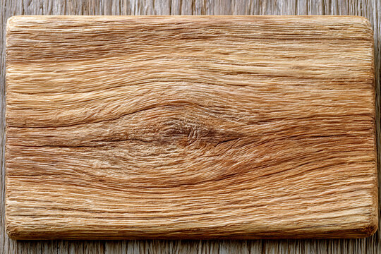 Rectangular piece of natural oak wood showing detailed grain patterns and a visible knot