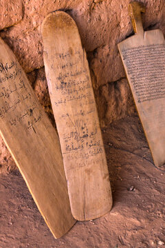Wooden boards with Arabic script leaning against a mud wall in a Koranic school, Sahel Region, Bani, Burkina Faso