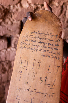 Hand holding a wooden board with Arabic text and letters in a Koranic school, Sahel Region, Bani, Burkina Faso