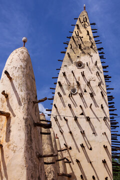 Pointed mud minarets of the Grand Mosque with wooden beams against blue sky, Hauts-Bassins Region, Bobo Dioulasso, Burkina Faso