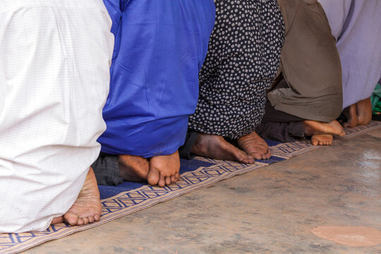 Bare feet of Muslim men kneeling on a mat during prayer at the Grand Mosque, Hauts-Bassins Region, Bobo Dioulasso, Burkina Faso