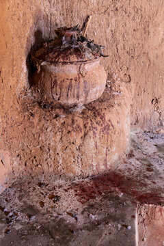 Fetish clay pot covered with feathers and blood in a mud wall niche, Hauts-Bassins Region, Bobo Dioulasso, Burkina Faso