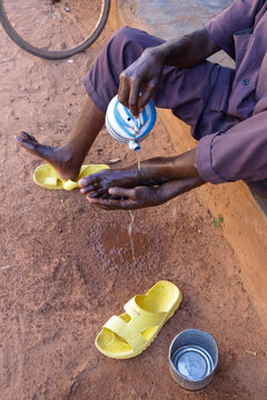 Muslim washing his feet with a kettle during ablutions, Hauts-Bassins Region, Bobo Dioulasso, Burkina Faso