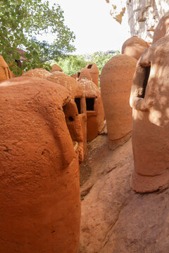 Rows of round clay granaries among the rocks of the Abandoned Troglodyte Village, Cascades Region, Niansogoni, Burkina Faso
