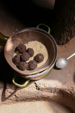 Lobi tribe food of dark balls on white grain in a metal pot, Sud-Ouest Region, Gaoua, Burkina Faso