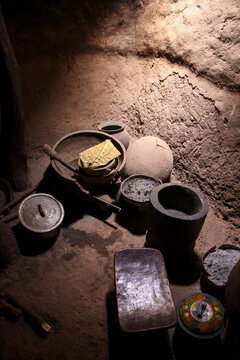 Clay pots and a wooden mortar inside a dark soukala house in Lobi tribe, Sud-Ouest Region, Gaoua, Burkina Faso