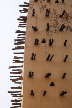 Close up of a mud wall of the grand mosque with protruding wooden beams, Hauts-Bassins Region, Bobo Dioulasso, Burkina Faso