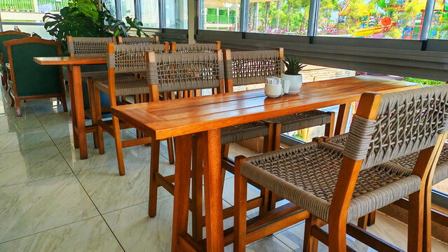 Wooden dining table with woven chairs in a bright room