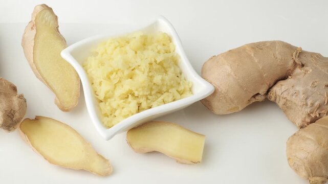 Camera moving over grated and sliced ginger isolated on white background
