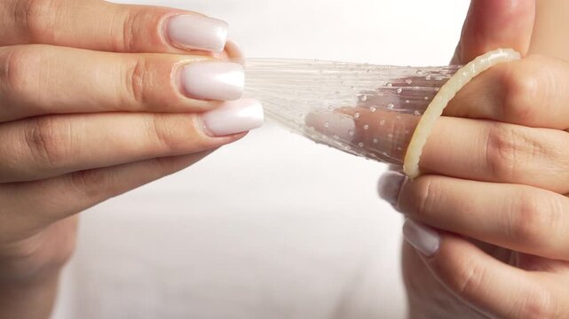closeup. female hands unwrapping condom. Safe love, healthcare, health, contraception, HIV and AIDS prevention, relationships and passion.