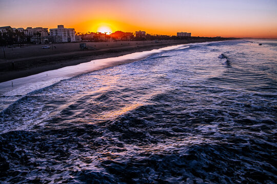 Sunset over Santa Monica beach and ocean waves in california