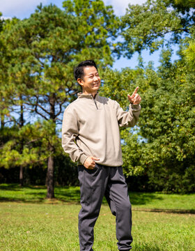 Outdoor portrait of friendly middle age asian male, relaxed casual outfit on sunny day
