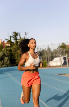 Young woman running on track practicing exercise