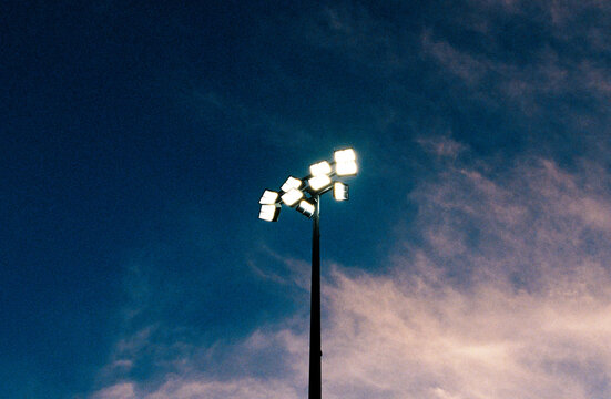 Stadium lights abstract against purple sky on film