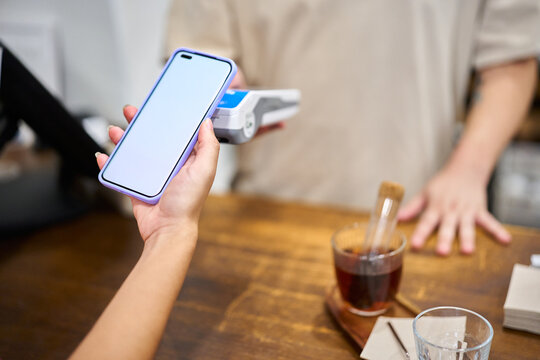 Person paying for coffee using smartphone contactless payment