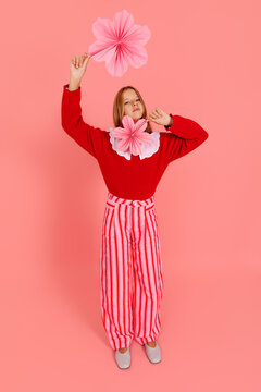 Girl posing with pink paper flowers o