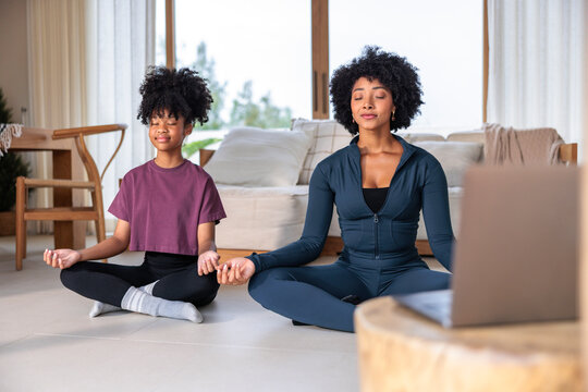 Mom and daughter meditate together