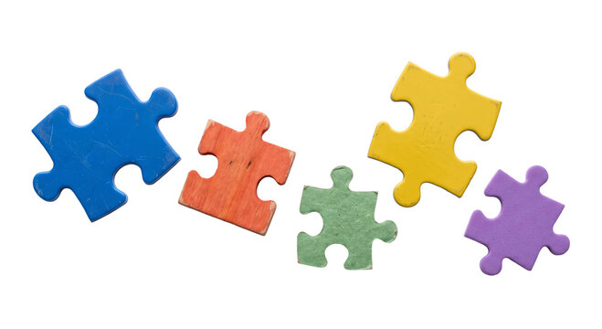 Five colorful jigsaw puzzle pieces scattered on a clean white background for creative concepts