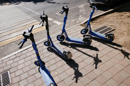 Abandoned electric scooters parked on city sidewalk