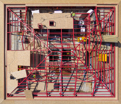 Aerial View Of Red Steel Roof Truss Framing And OSB Panels