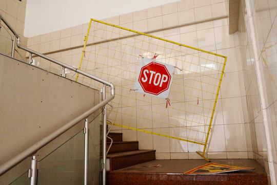 Stop sign attached to yellow barrier on abandoned staircase