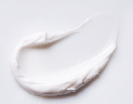 Thick white skincare cream smear with fine ridges on a white surface
