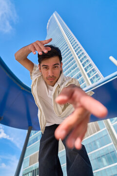 Young man extending arm reaching for camera