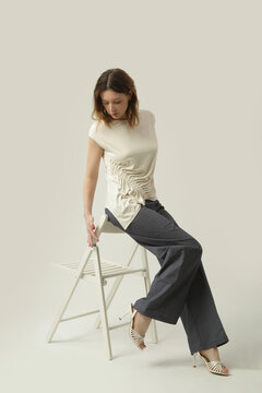 Female Fashion Model Wearing White Asymmetric Ruched Top Paired with Blue Cotton Denim Wide Leg Pants, Casual and Comfortable Yet Stylish Summer Outfit