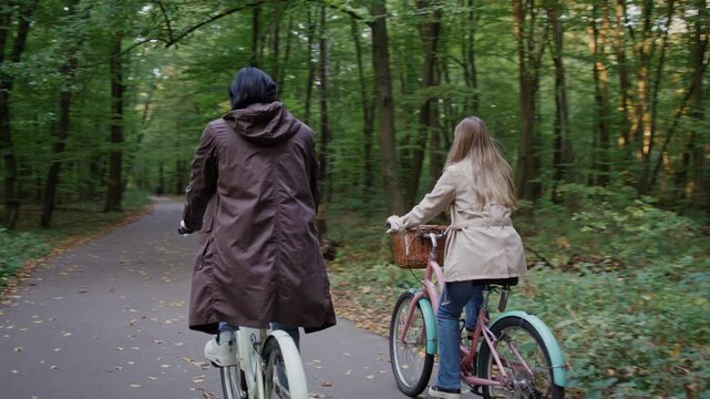 Couple rides bicycles together along peaceful forest pathway