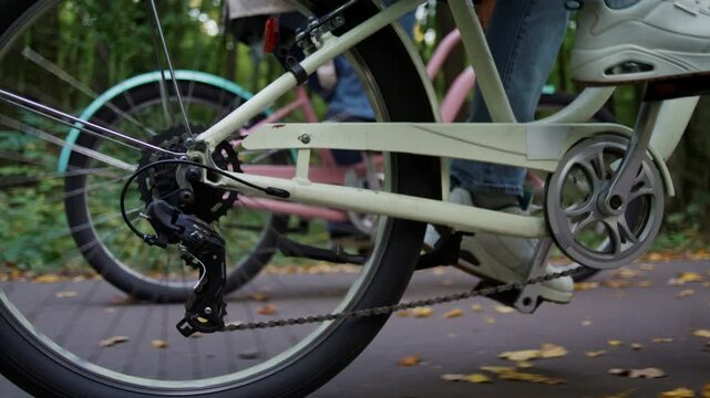 Male sneakers push bicycle pedal during autumn forest riding