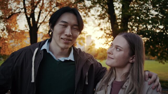 Couple in love looks at each other during warm autumn park sunset