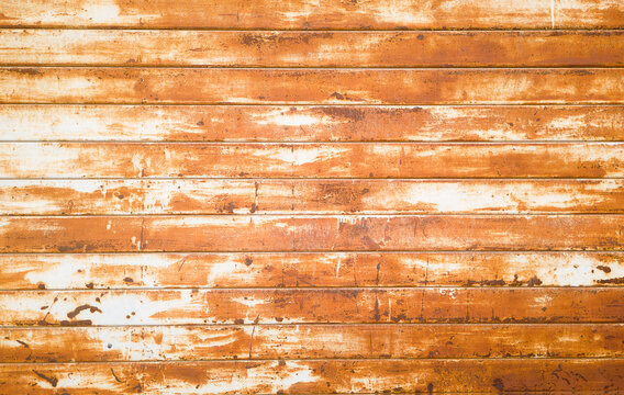 Abstract-looking background texture of a rusted and worn metal wall with parallel elements.