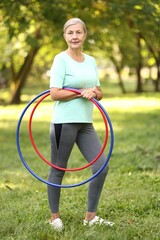 Senior woman with hula hoops in park © New Africa