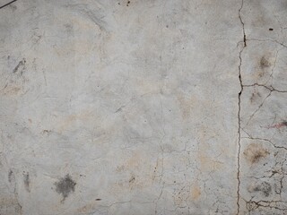 Cracked weathered concrete wall surface creating an aged textured background © Harry
