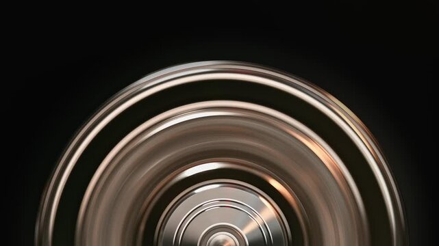 Extreme close-up of a spinning metallic disc. Motion blur effect on chrome surface, ideal for industrial, technology, and energy visual themes.
