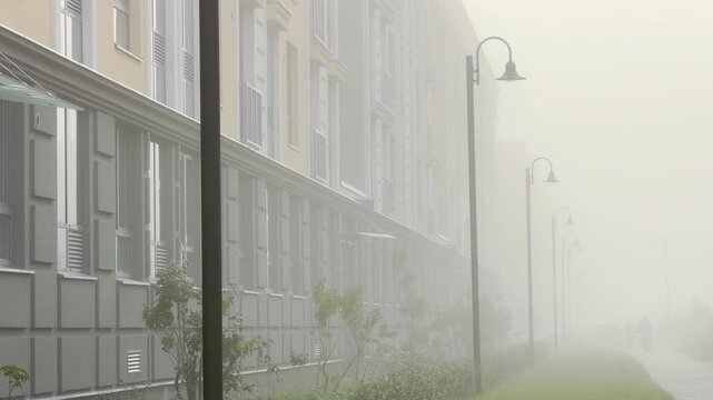 Street lamps line a residential building fading into thick fog. The quiet street creates a mysterious and peaceful mood. Welcome to Pushkin, Saint Petersburg.