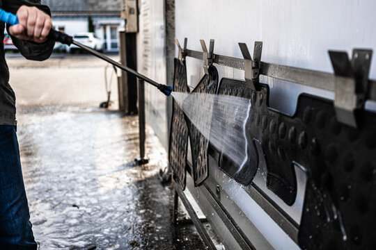 High pressure washing of rubber car floor mats at station