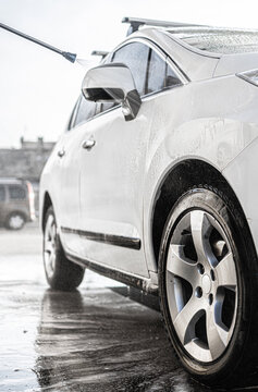 Washing white car with high pressure water jet