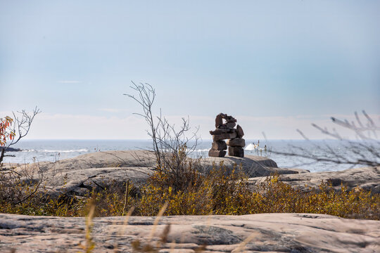 Scenic view of an Inukshuk on rocky shores of Georgian Bay, Lighthouse Trail, Killarney, Ontario.