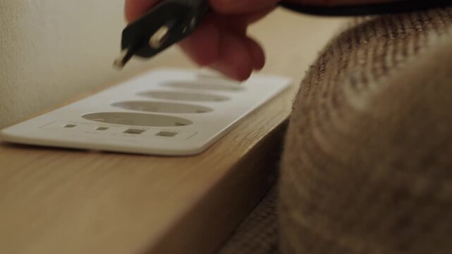 Person unplugging power cord from wall socket at home