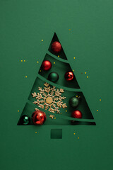 Obraz premium Christmas tree vertical paper cutout with baubles and snowflake on a vertical green festive background