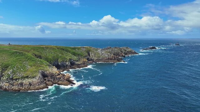 Aerial view of the Pointe du Raz headland on the stormy Breton coast, at whose edges the ocean spray breaks white, on the horizon the historic lighthouse Phare de la Vieille, Plogoff, Cap Sizun, Fini