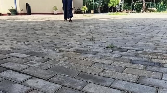 Low Angle Woman Legs Walking on Interlocking Paving Stones Sunlight to Shadow