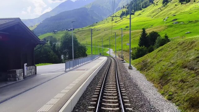 Front View From Glacier Express Train on Railroad Tracks and Mountainscape and Valley in a Sunny Summer Day in Sedrun, Surselva, Oberalp, Grisons, Switzerland