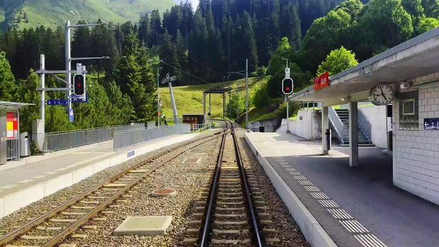 Rear View From the Glacier Express Train on Railroad Tracks and Swiss Alps in Mountain Valley in a Sunny Summer Day in Sedrun, Surselva, Oberalp, Grisons, Switzerland. (Time Lapse)