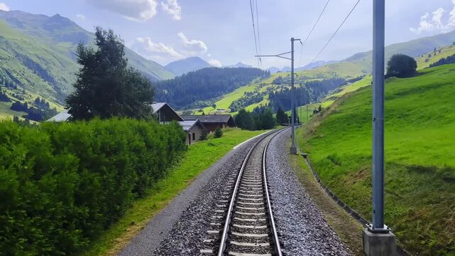 Rear View From Glacier Express Train on Railroad Tracks and Mountainscape and Mountain Valley in a Sunny Summer Day in Sedrun, Surselva, Oberalp, Grisons, Switzerland