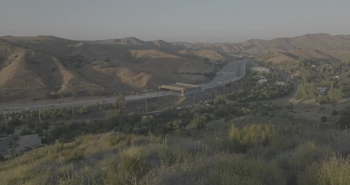Wide Aerial Panorama of Dry Hills and a Distant Highway Wildlife Crossing
