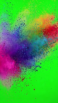 Multi colored rainbow powder spectrum exploding and scattering across a green screen chroma key
