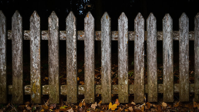 Old weathered wooden picket fence with rustic distressed texture